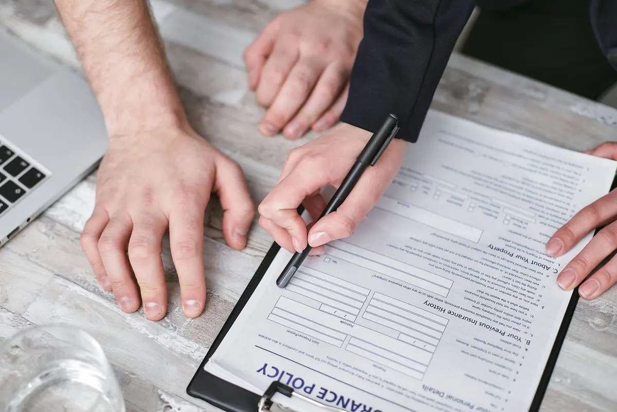 Photo professionnelle d'une équipe RH présentant un contrat de prévoyance collective à des salariés souriants
